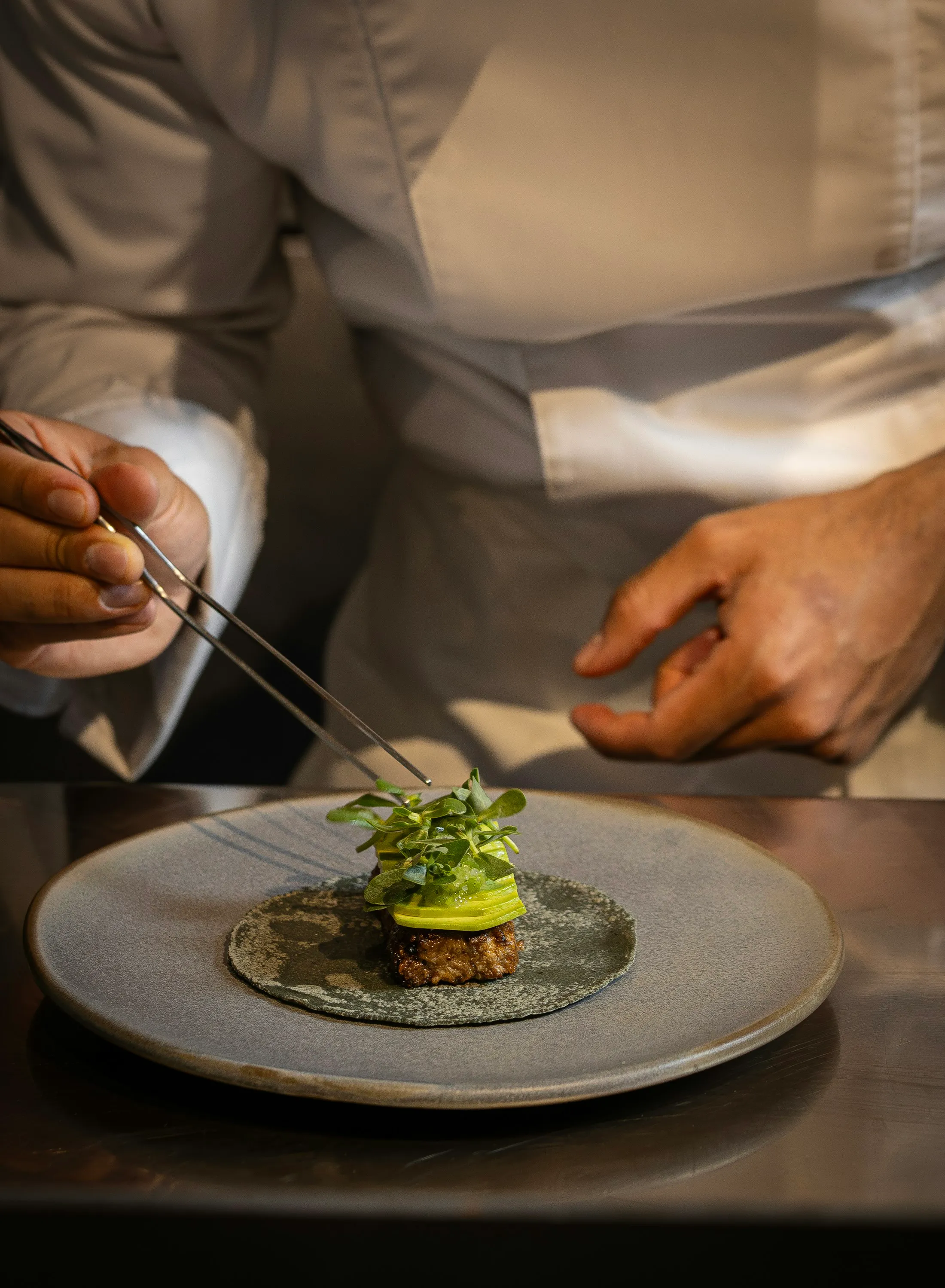 Le chef dresse une assiette du menu à la pince
